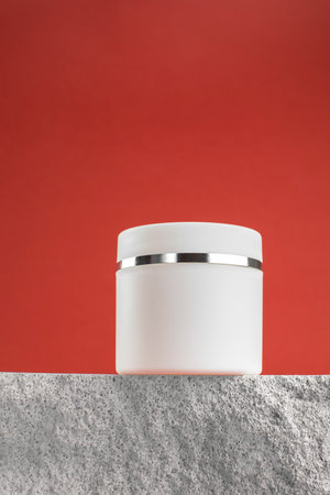 Mockup of a white jar of cream on a stone podium. Closed white jar with moisturizerの写真素材