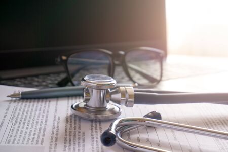 stethoscope lay on  computer with pen and glasses, documents. work spase of doctor.の写真素材