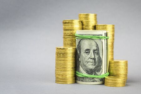 hundred dollar banknote with gold coins on a gray background. financial conceptの写真素材