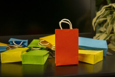 online shopping concept. little colorful shopping bags stand on laptop. copy spaceの写真素材