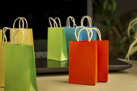 online shopping concept. little colorful shopping bags stand on laptop. copy spaceの写真素材