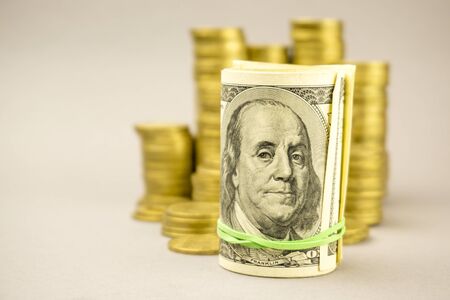 hundred dollar banknote with gold coins on a gray background. financial concept