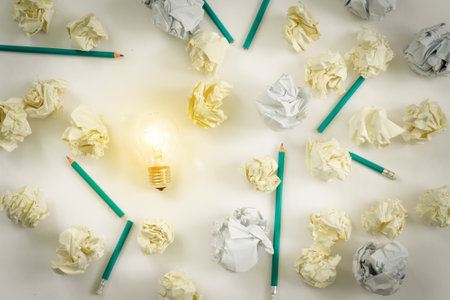 new ideas concept. shining bulb , paper balls, colorful pencils on white backgroundの写真素材