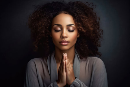 Experience a moment of deep reflection as an African American woman prays and meditates, finding solace and spiritual connection in a serene oneness with herself.の素材
