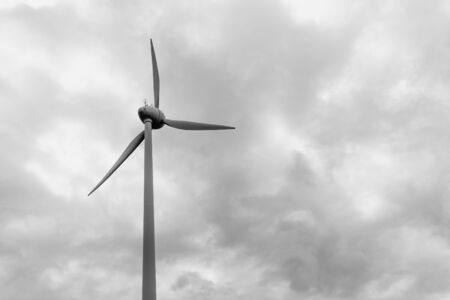 Wind turbine under cloudy sky, black and white bw. View from the ground. Windfarm, wind power plant.の写真素材