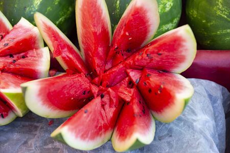 Slices of red watermelon on a fruit and vegetable street market