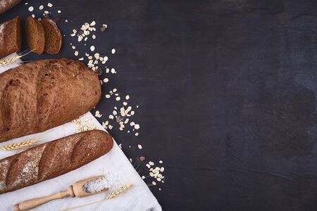 Bread border on wood with copy space background. Brown and white whole grain loaves still life...