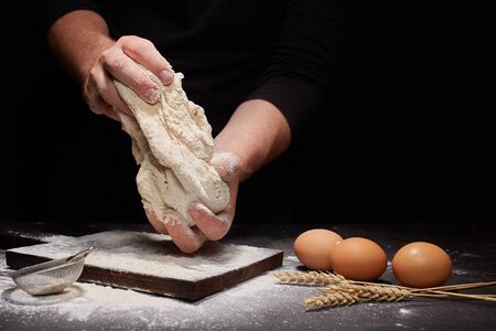 man Baker and his hands over the bread from whole wheat flour (to oven). flour, rustic style