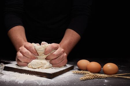 man Baker and his hands over the bread from whole wheat flour (to oven). flour, rustic style