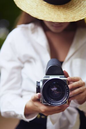 Young woman looking through camera lensの写真素材
