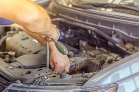 Mechanic hands checking up of serviceability of the car in open hood, close up