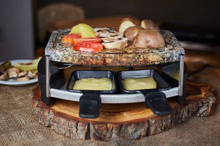 Swiss raclette. A table filled with ingredients.の写真素材