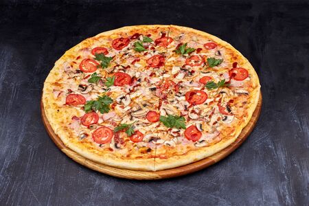 Fresh pizza with BBQ sauce on wooden cutting board. isolated on dark background.の写真素材