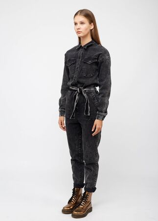 Girl in black denim jumpsuit on white background.の写真素材