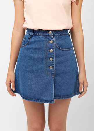 Teenager girl in a denim blue skirt on a white background.の写真素材