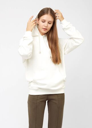 Portrait of young woman wearing grey sportswear sweatshirt hoodie, isolated studio image on white backgroundの写真素材