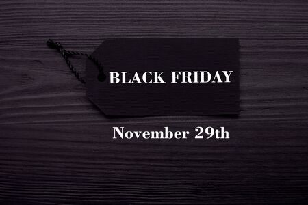 Black Friday text on a black tag on black paper backgroundの写真素材