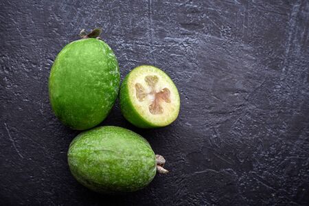 Green feijoa fruits on blue concrete background table. Tropical fruit feijoa. Set of ripe feijoa fruits.の写真素材