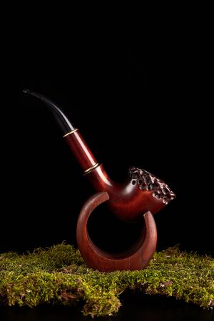 Tobacco pipe with smoke isolated on black background.
