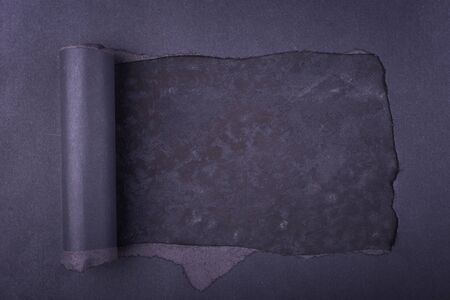 Big hole in the black paper. Torn. Concrete background. Abstract background.の写真素材