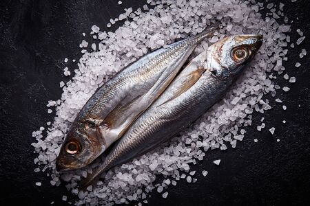 Two horse mackerels in sault on the kitchen table.