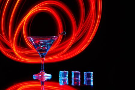 Neon martini glass shot with long exposure. Red club lights.の写真素材