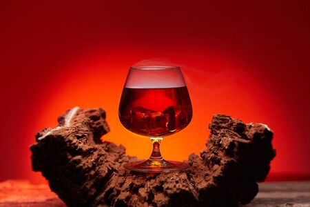 glass of whiskey on wooden table , red tint atmosphere, time of relax with whiskyの写真素材