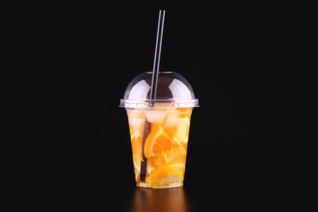 Lemonade to go cup with mint, orange and lemon on black background, isolatedの写真素材