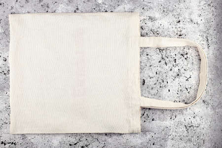 Blank cotton tote bag, design mockup. Handmade shopping bag on concrete table. Mockup.の写真素材