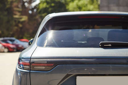 Back window of a car parked on the street in summer sunny day, rear view. Mock-up for sticker or decalsの写真素材