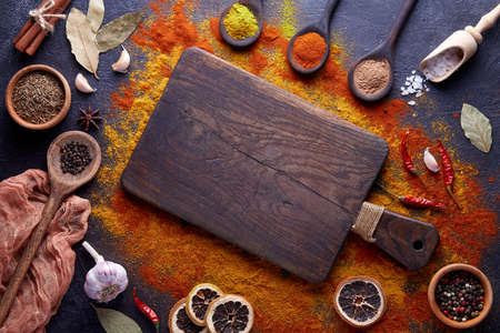 Cutting board with spices and herbs for cooking meat on dark backgroundの写真素材