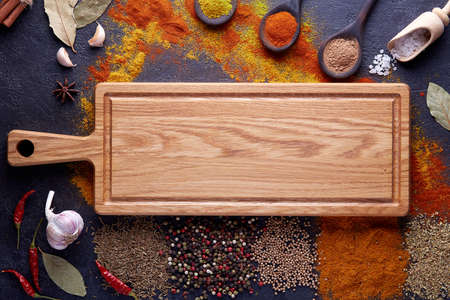 Cutting board with spices and herbs for cooking meat on dark backgroundの写真素材