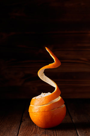 A flying peeled orange on the wooden backgroundの写真素材