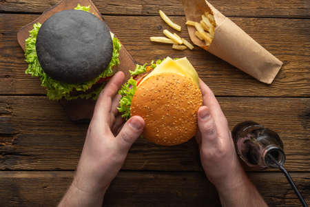 Fresh tasty burgers with french fries, drink on the wooden table top view.の写真素材