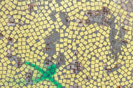 Old yellow mosaic wall with hole and rust, background from old mosaic.の写真素材