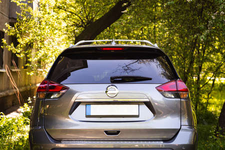 Back window of gray car parked on the street in summer sunny day, rear view. Mock-up for sticker or...
