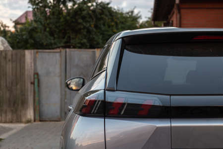 Back window of grey car parked on the street in summer sunny day, rear view. Mock-up for sticker or...