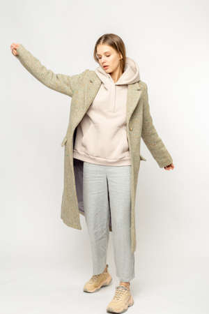 Girl in a beige coat isolated on white background