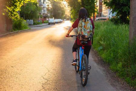 Young lady with bicycle on a rural roadの写真素材