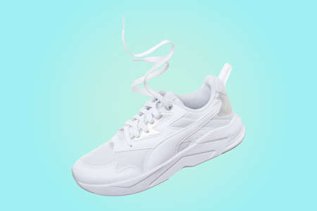 White flying sneakers on blue and yellow gradient backgroundの写真素材