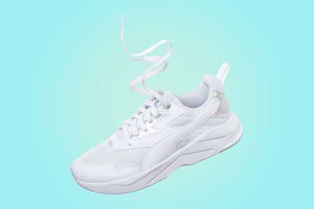 White flying sneakers on blue and yellow gradient backgroundの写真素材