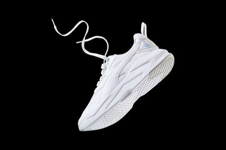 White flying sneakers isolated on black backgroundの写真素材