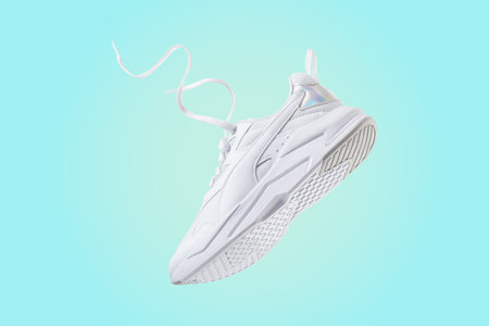 White flying sneakers on blue and yellow gradient backgroundの写真素材
