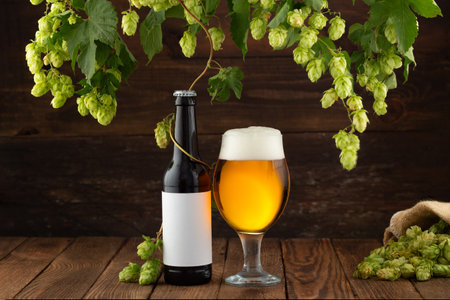 Glass of beer on a wooden table. Mock up of bottle beer. Oktoberfest. Hopsの写真素材