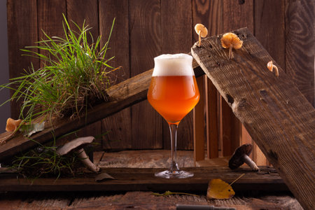 A glass of beer on a wooden table.の写真素材