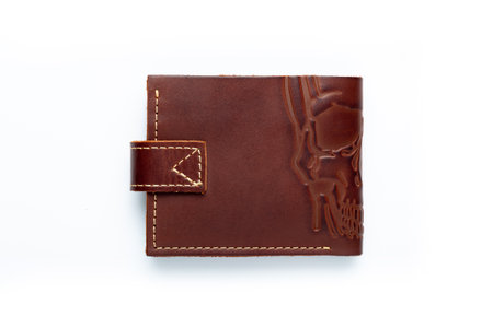 Brown leather wallet on a button on a white background, scull print. top viewの写真素材