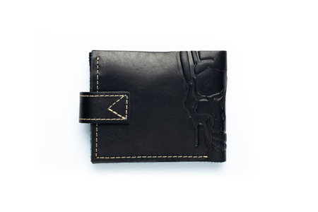 Black leather wallet on a button on a white background, scull print. top viewの写真素材