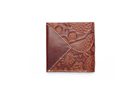 Small brown leather wallet on a button on a white background, birds print. top viewの写真素材