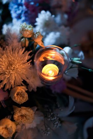 Festive decor with flowers and a candle on the table.の写真素材