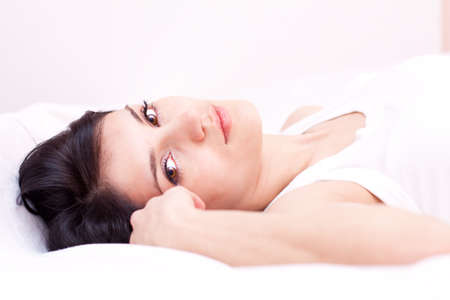 Good looking girl on the bed in bedroomの写真素材